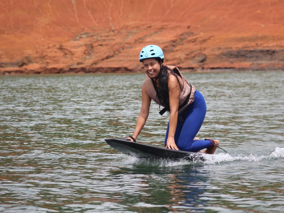 Rider principiante con casco y chaleco salvavidas, sonriendo mientras aprende a volar el eFoil